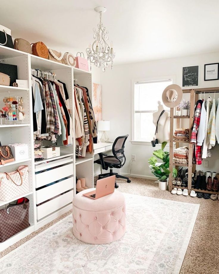 an organized closet with clothes, shoes and handbags on shelve shelves in front of a chandelier