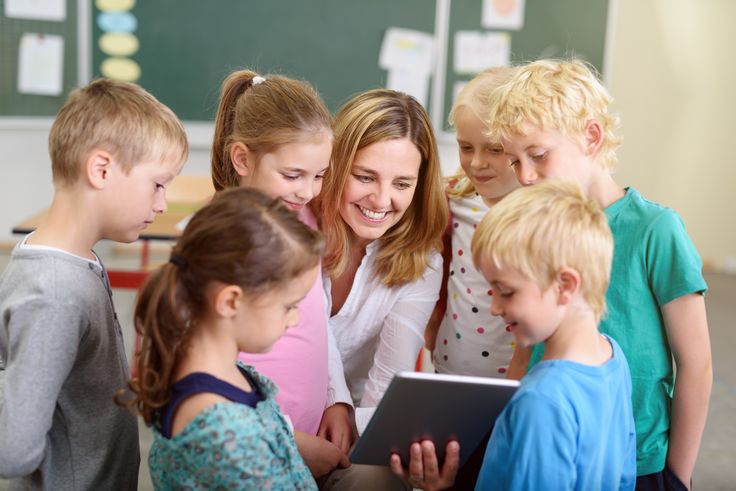 a group of children looking at something on a tablet