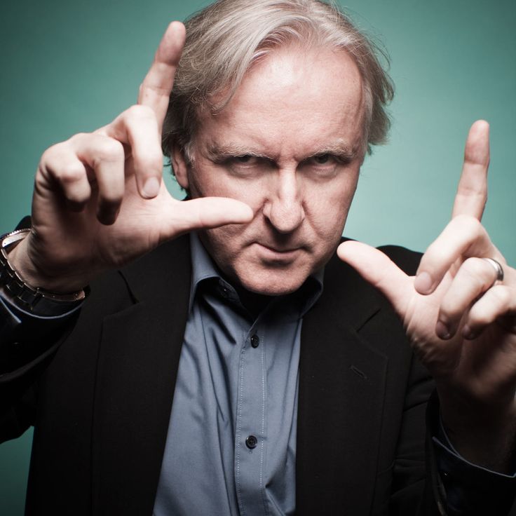 a man in a suit making the middle finger sign with his fingers and looking at the camera