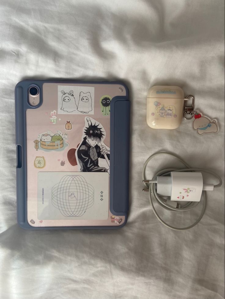 an ipad case, charger and other items on a bed