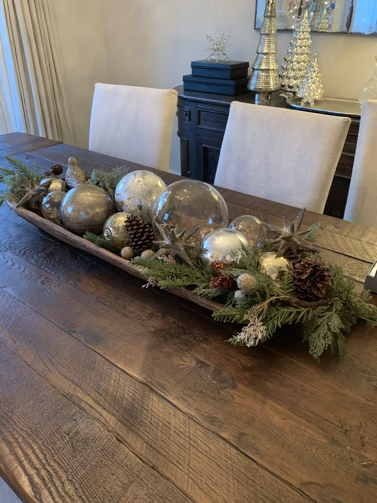 a wooden table topped with ornaments and pine cones