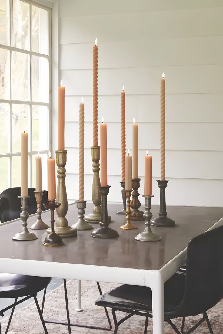 a dining room table with many candles on it