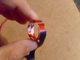 a hand holding a piece of red and white tape