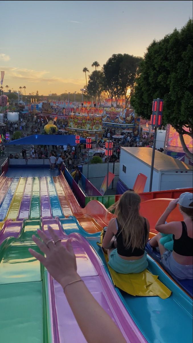 people are riding roller coasters at an amusement park