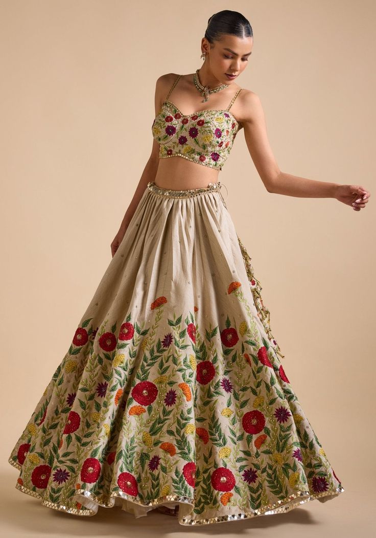 Elevate your ethnic wardrobe with Ivory Embroidered Lehenga. Crafted from luxurious silk, the lehenga features intricate thread, sequin, and cutdana embroidery in stunning floral patterns. Teamed with a modern cut embroidered strappy blouse and a beautifully adorned dupatta. This ensemble is ideal for a bride or bride-to-be, ensuring an unforgettable, elegant look for your special day. Composition : Skirt & Blouse - Silk, Dupatta - Net Care: Dry Clean Only and Vacuum Storage This product can be Navratri Floor-length Sets With Floral Embroidery, Floral Embroidered Raw Silk Sharara, Traditional Raw Silk Sharara With Floral Embroidery, Floor-length Floral Embroidery Choli For Festive Occasions, Festive Floor-length Floral Embroidery Choli, Floor-length Lehenga With Floral Embroidery For Festivals, Floral Embroidered Raw Silk Traditional Wear For Reception, Floral Embroidered Raw Silk Sharara For Receptions, Raw Silk Sharara With Floral Embroidery For Reception