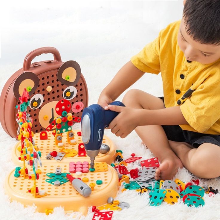 a young boy playing with toys on the floor