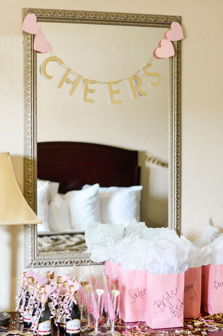 pink and white bags are sitting on a table in front of a mirror that says cheers