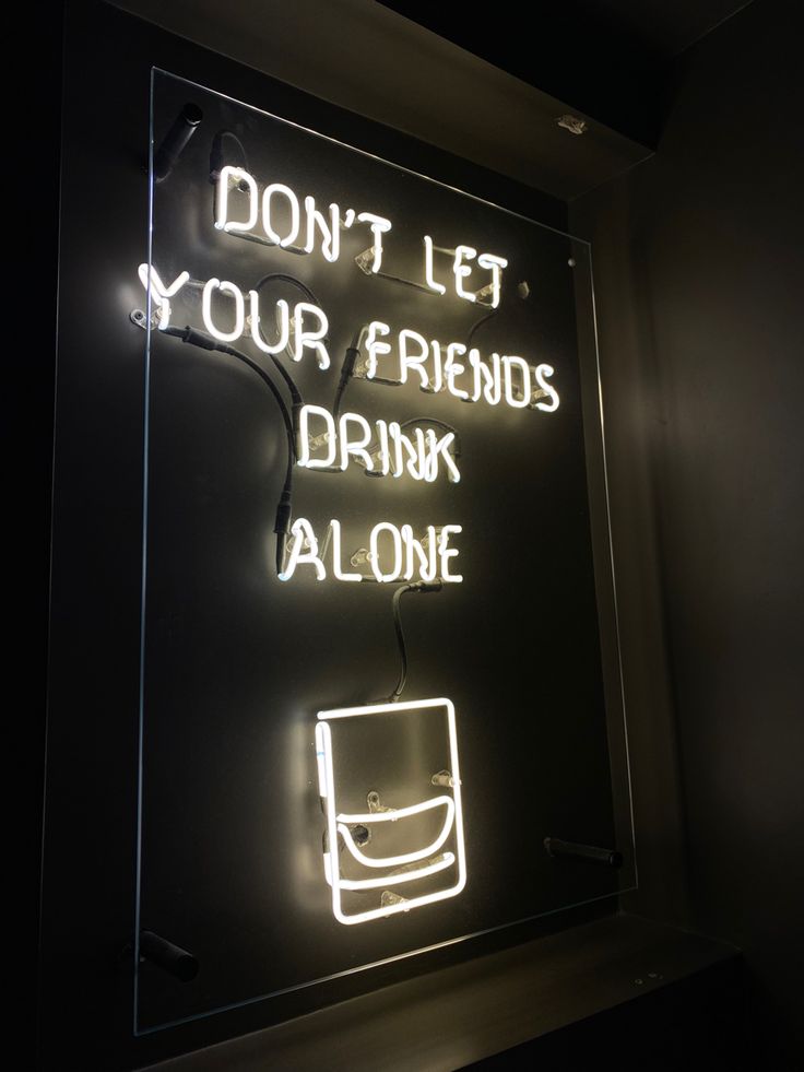 a neon sign that says don't let your friends drink alone on the wall