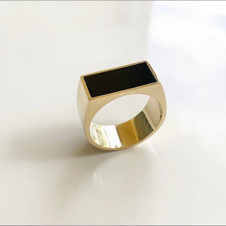 a gold and black ring on a white surface