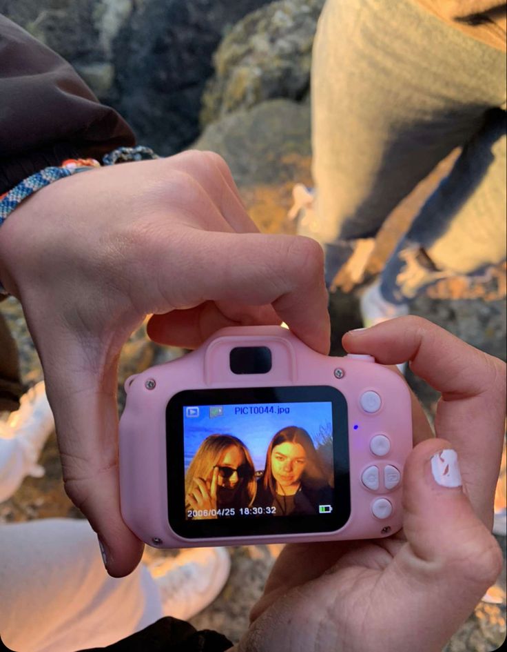 a person holding a pink camera in their hand