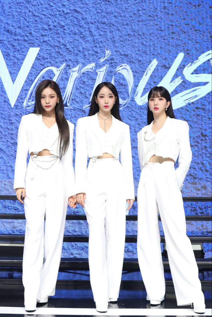 three women in white outfits standing next to each other