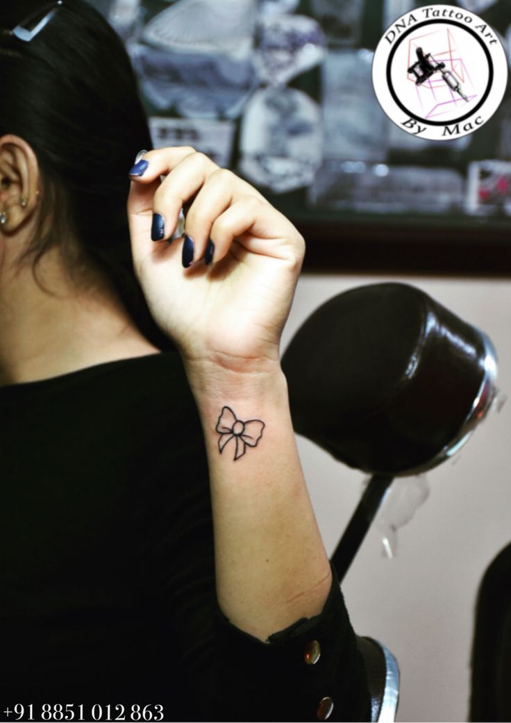 a woman with a bow tattoo on her wrist