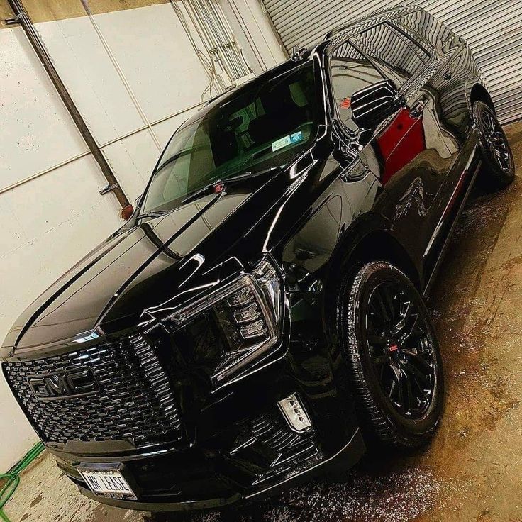 the front end of a black truck parked in a garage