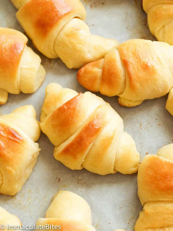 freshly baked croissants on a baking sheet ready to be cooked in the oven