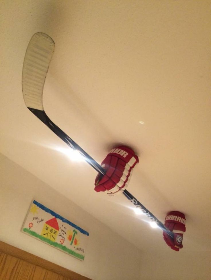 the ceiling is painted white and has hockey sticks hanging from it's sides with red hats on them