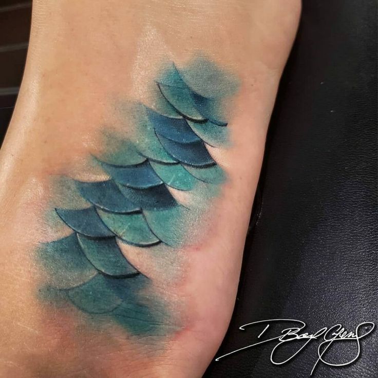 a tattoo with blue watercolors on it