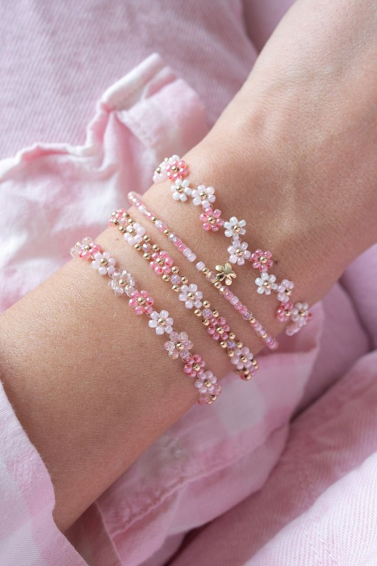 a woman's arm with pink and white bracelets on it