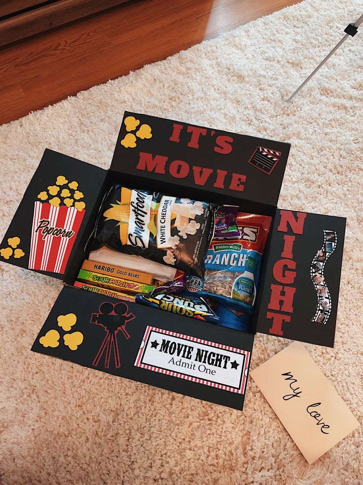 an open movie box sitting on the floor next to a sign that says it's movie night