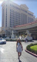 a woman is walking down the street in front of a hotel