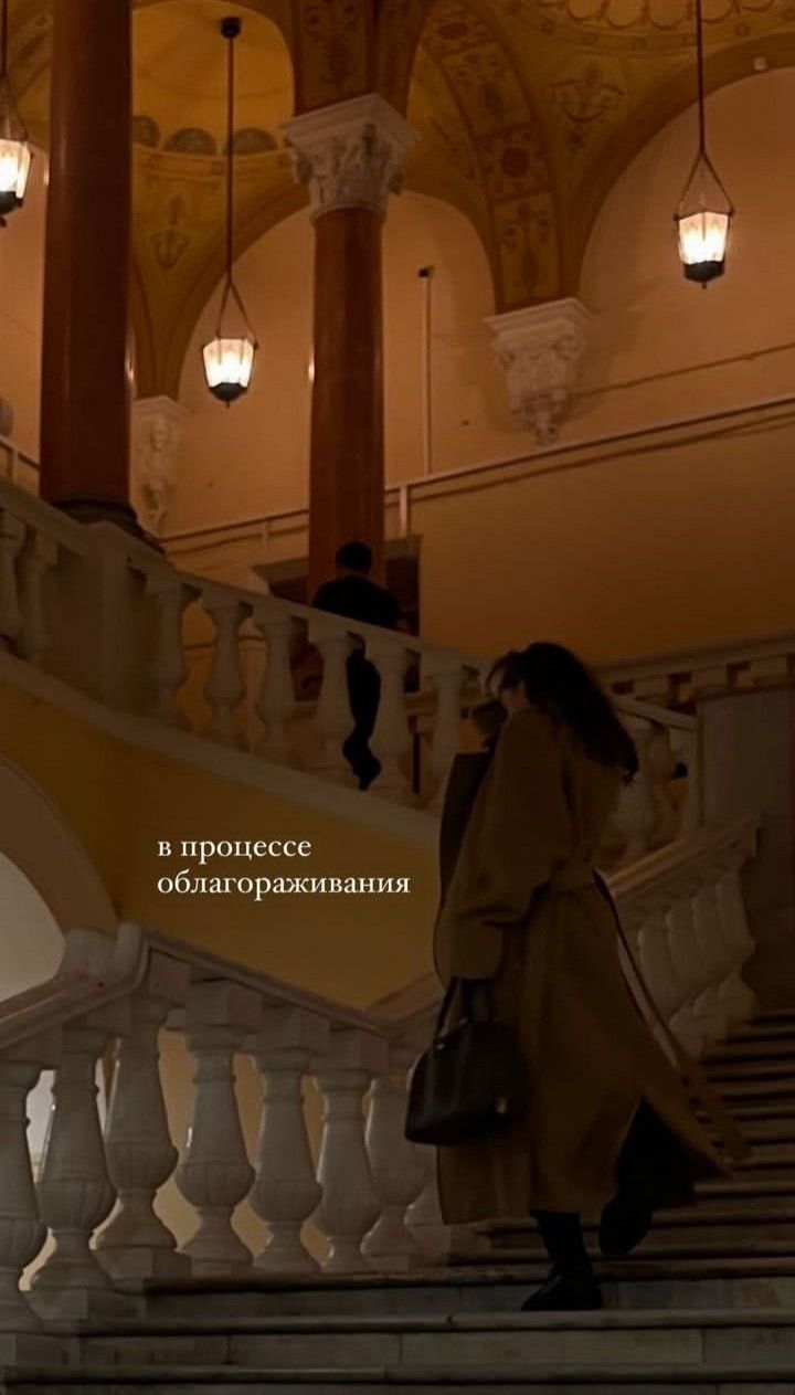 a woman is walking down the stairs in an ornate building