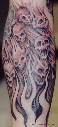 a man's leg with skulls and flames on it