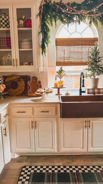 a kitchen with white cabinets and black and white checkered rug