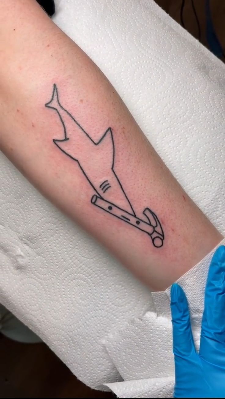 a tattoo on the arm of a person with gloves and blue gloves around their ankles