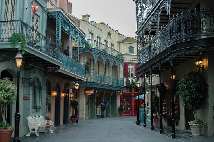 an empty street in the middle of a city with lots of balconies and wrought iron railings