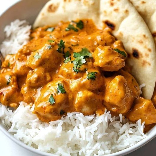 a bowl filled with rice and chicken next to pita bread on top of it