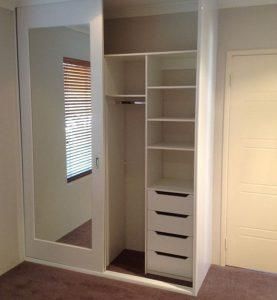 an empty closet is shown with the door open to reveal it's storage space