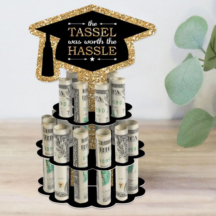 a black and gold graduation cap on top of stacks of money with the words tassel was worth the hassle