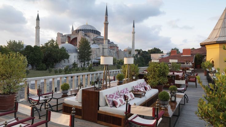 an outdoor seating area on the roof of a building with a mosque in the background