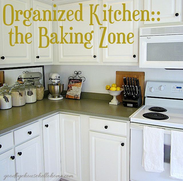 a kitchen with white cabinets and yellow lettering on the wall that says organized kitchen the baking zone