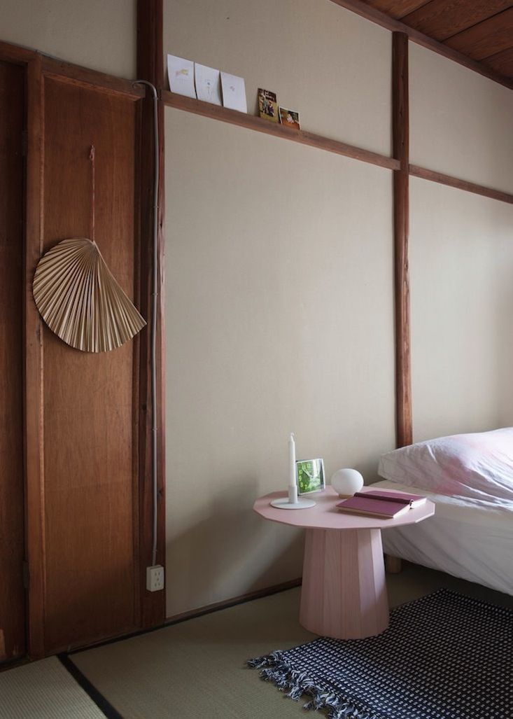 a bed sitting next to a wooden door in a bedroom on top of a rug