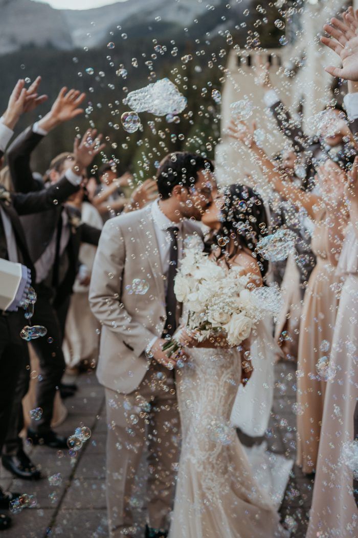 a bride and groom are surrounded by bubbles