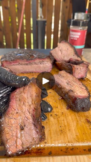 the steaks are being cooked on the cutting board with tongs and seasoning