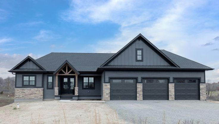 a large gray house with two garages