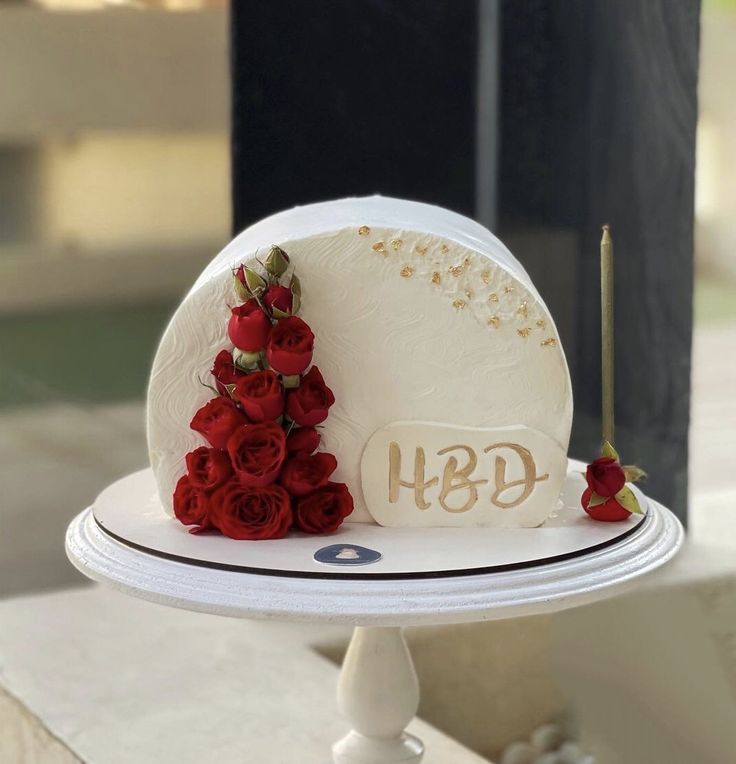 a white cake with red roses on top