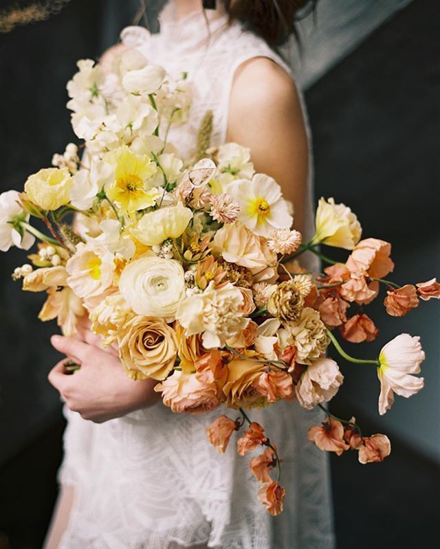 a woman holding a bouquet of flowers in her hands