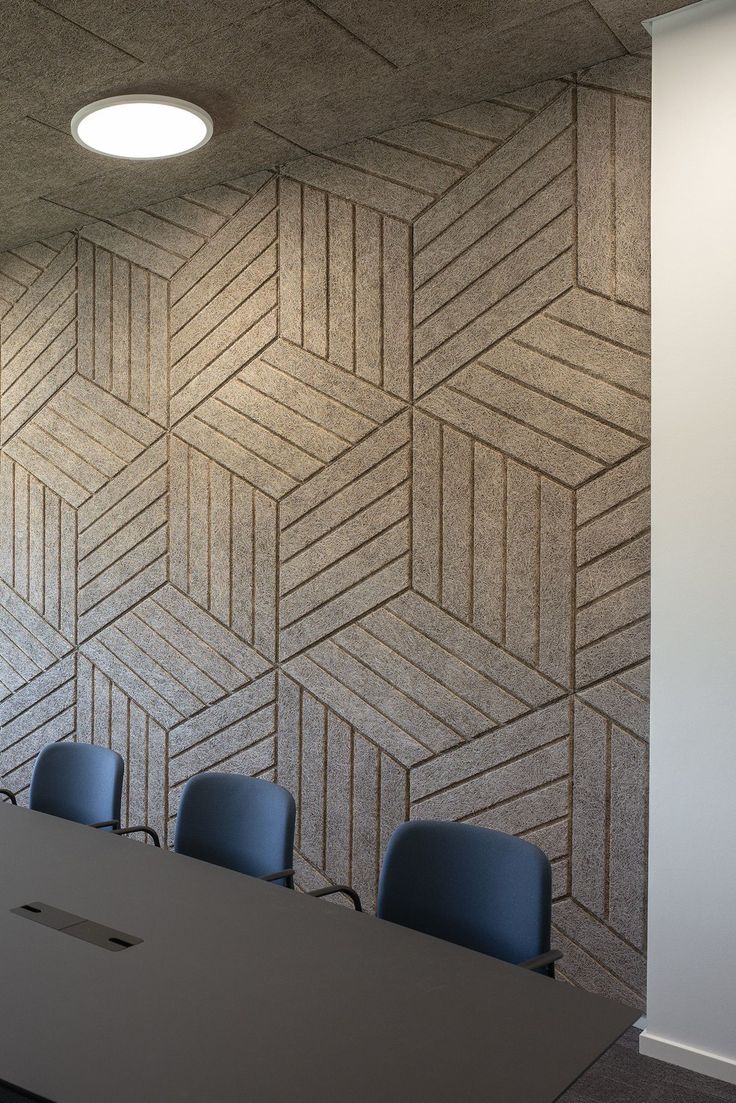 an empty conference room with blue chairs in front of a wallpapered pattern on the wall