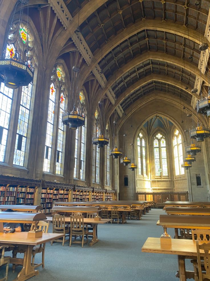 the inside of a large library with tables and benches in it's center area