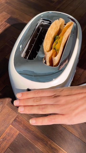 a person is reaching for some food in a toaster