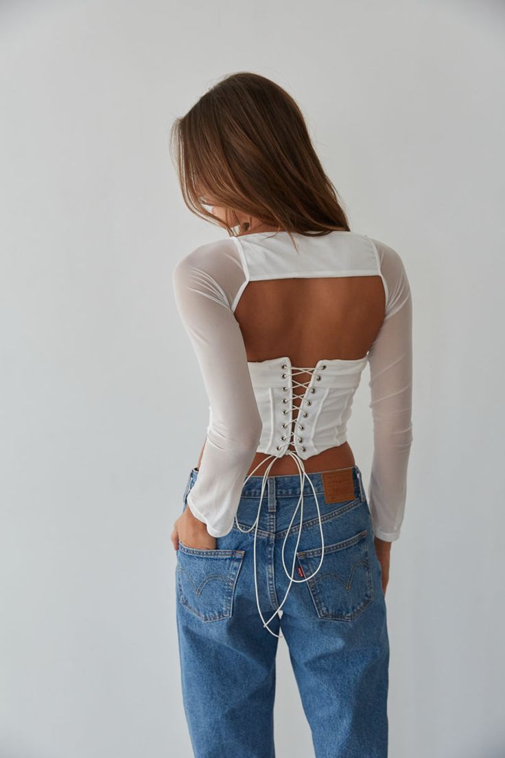 So trendy in the Rio Corset Shrug Set! This corset top is complete with a strapless fold over neckline, a lace up back with silver grommets, and a mesh long sleeve shrug. Available in black and white. Pair with your favorite jeans to complete the look! Details Top self: 95% Nylon, 5% Spandex Top lining 92% Polyester, 8% Spandex Shrug self: 90%, Nylon, 10% Spandex Shrug lining: 92% Polyester, 8% Spandex Item sold as set Silicon grips Boning Material has some stretch Machine wash cold / Tumble dry Fitted Crop Top With Lace-up Back For Party, Fitted Lace-up Back Crop Top For Spring, Fitted Crop Top With Lace-up Back For Spring, Fitted Lace-up Back Top For Spring, Spring Stretch Tops With Lace-up Back, Fitted Backless Top With Corset Back, Spring Tops With Corset Back And Stretch, Spring Stretch Crop Top With Corset Back, Spring Stretch Tops With Corset Back