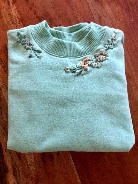 This soft sweatshirt is designed with modern embroidered flowers. A cozy sweatshirt that is great for wfh or paired with jeans and boots for a great spring look. Comfortable Cotton Sweater For Spring, Comfortable Cotton Spring Sweater, Comfortable Cotton Sweatshirt For Spring, Cozy Cotton Sweatshirt For Spring, Fall Embroidered Graphics Sweatshirt, Spring Embroidered Cotton Sweater, Spring Cotton Sweater With Floral Applique, Spring Cotton Embroidered Sweater, Cozy Cotton Sweater For Spring