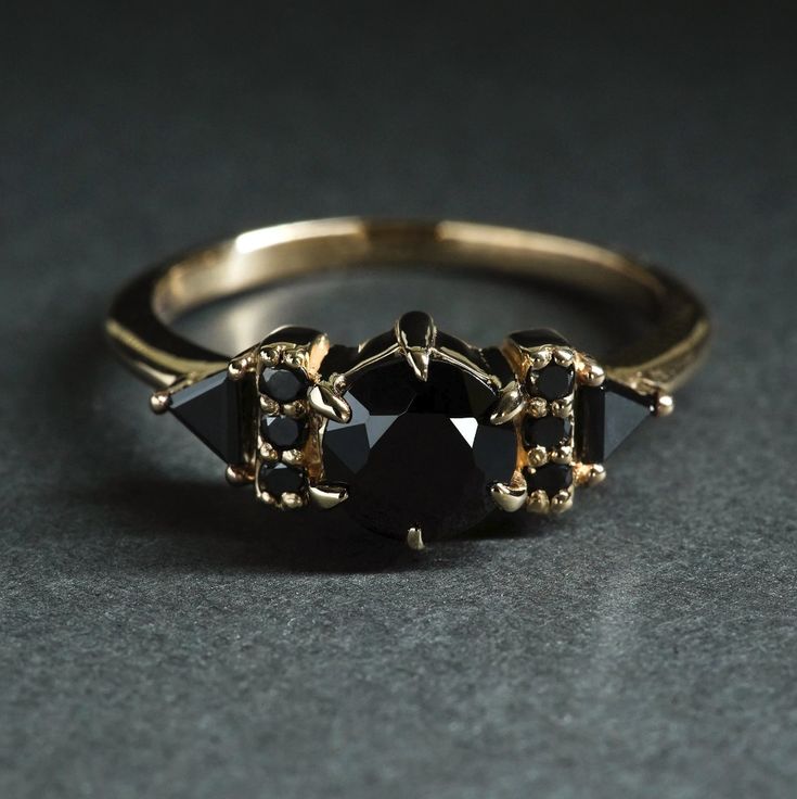 1 x 1ct black diamond center stone 2 x triangle cut black diamonds 6 x 1.5mm black diamonds If you are interested in creating a custom ring please contact us here. This ring can be made in any size, simply leave a note during checkout with your needed size if you don't see it in the drop down options. This ring is hand Onyx Engagement Ring, Cute Engagement Rings, Black Gems, Black Diamond Ring Engagement, Black Diamond Ring, Custom Ring, Black Diamonds, Bling Rings, Emerald Engagement Ring