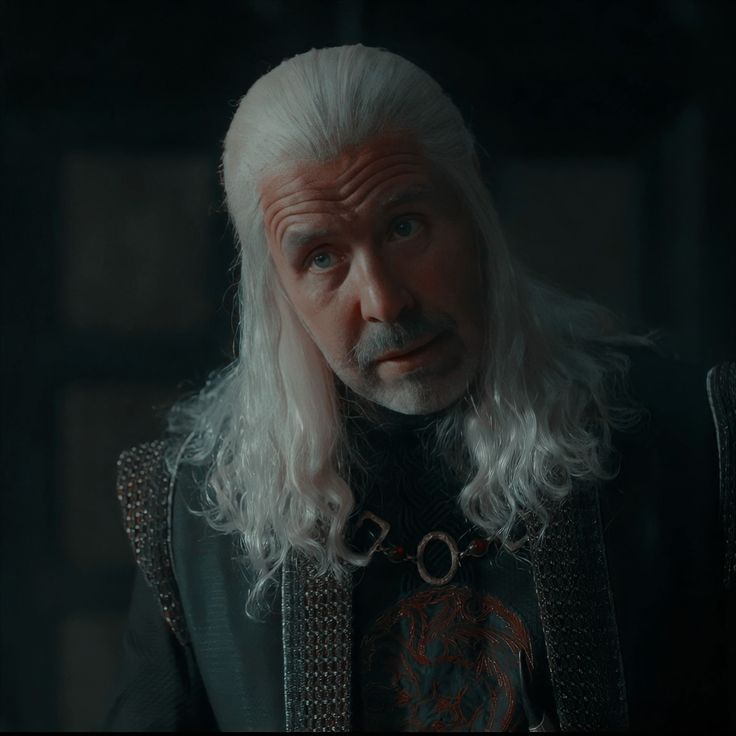 an older man with long white hair wearing armor