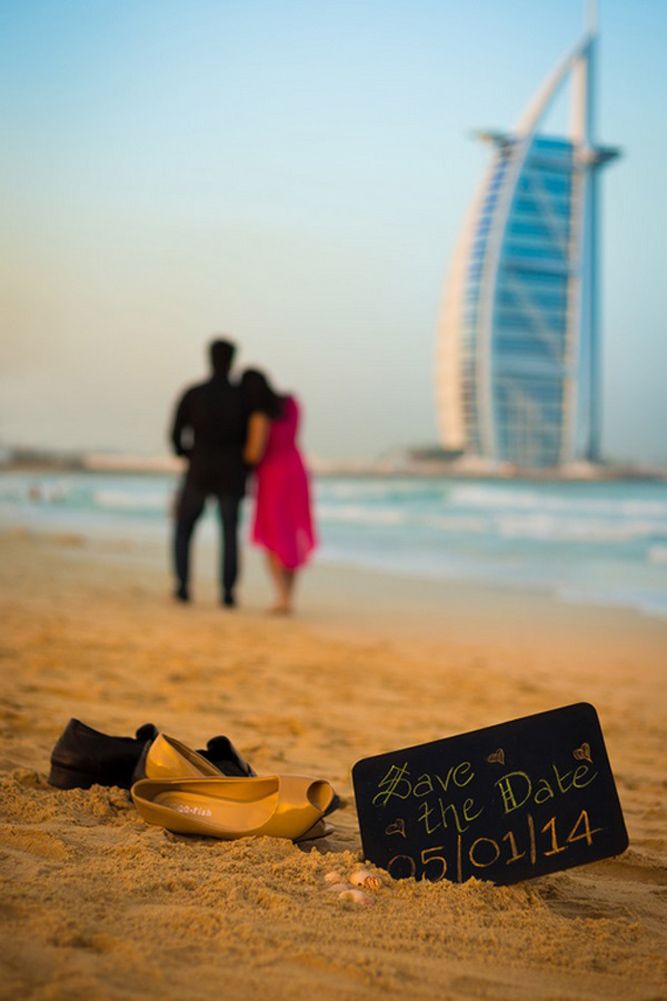 a couple standing on the beach next to a sign that says save the date 2013