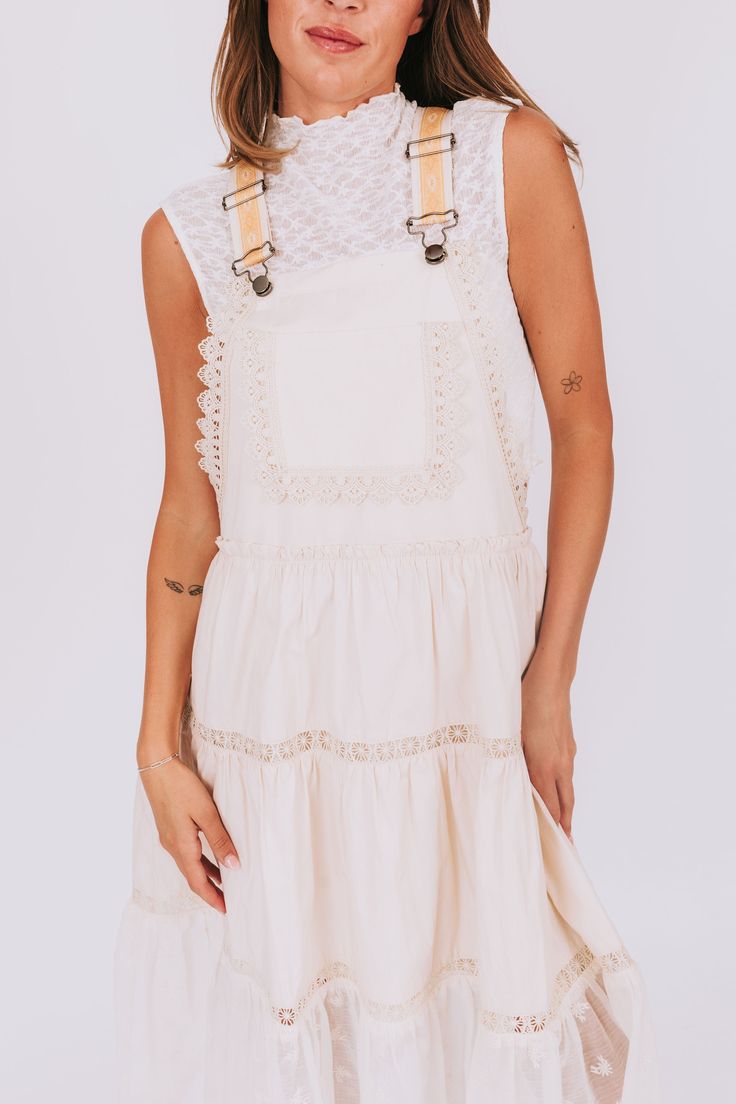 This dress is all about the details! The overall style is accented with lace trim and beautiful mesh and floral detailing. And don't forget the golden embroidery on the straps for a touch of glamour. Who says you can't have it all? Details Overall style Lace trim Mesh/floral detail Golden colored embroidery on straps Sizing Approximate measurements: SIZE LENGTH BUST Small 43" 36" Medium 44" 38" Large 46" 40" Fabric has no stretchModel is 5’8 wearing small Material 100% CottonHand wash coldHang t Casual Dresses With Lace Trim And Spaghetti Straps, Beige Lace Trim Dress For Summer, Summer Cotton Lace Dress With Lace Trim, Elegant Lace Suspender Dress With Lace Trim, Beige Lace Work Dress, Beige Lace Top Dress For Summer, Sleeveless Suspender Dress With Lace Trim For Spring, Spring Sleeveless Suspender Dress With Lace Trim, Lace Dresses With Crochet Trim And Spaghetti Straps