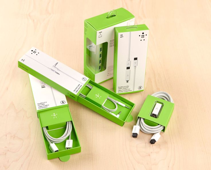 three green boxes are sitting on top of a wooden table and one is plugged into the charger