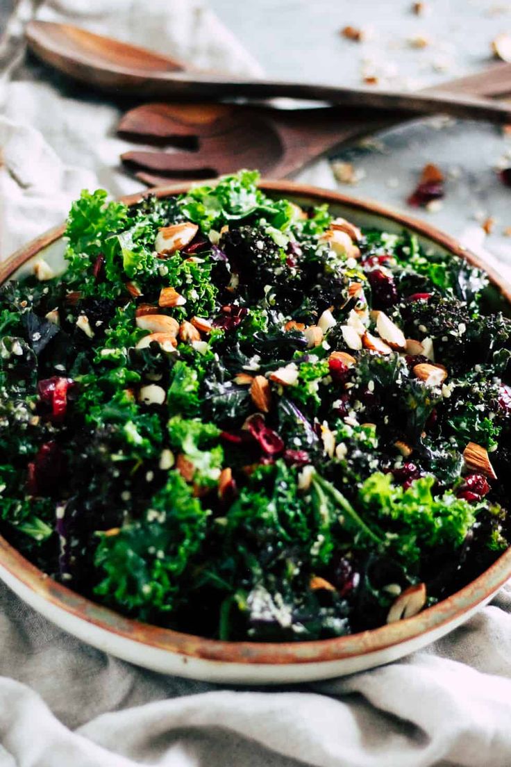 a close up of a bowl of food with broccoli and cranberry orange kale salad